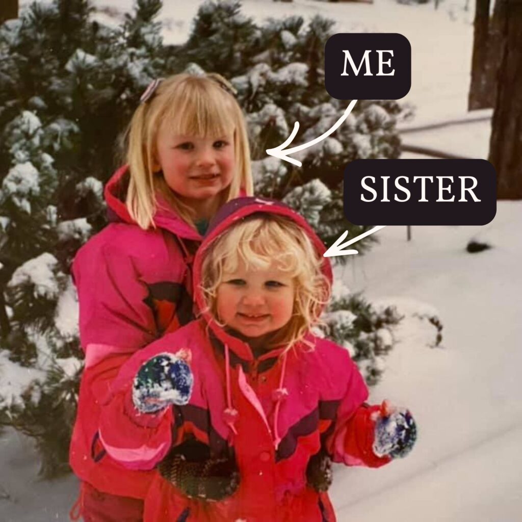 Ashley with her little sister in matching pink snowsuits playing in the snow circa 1992