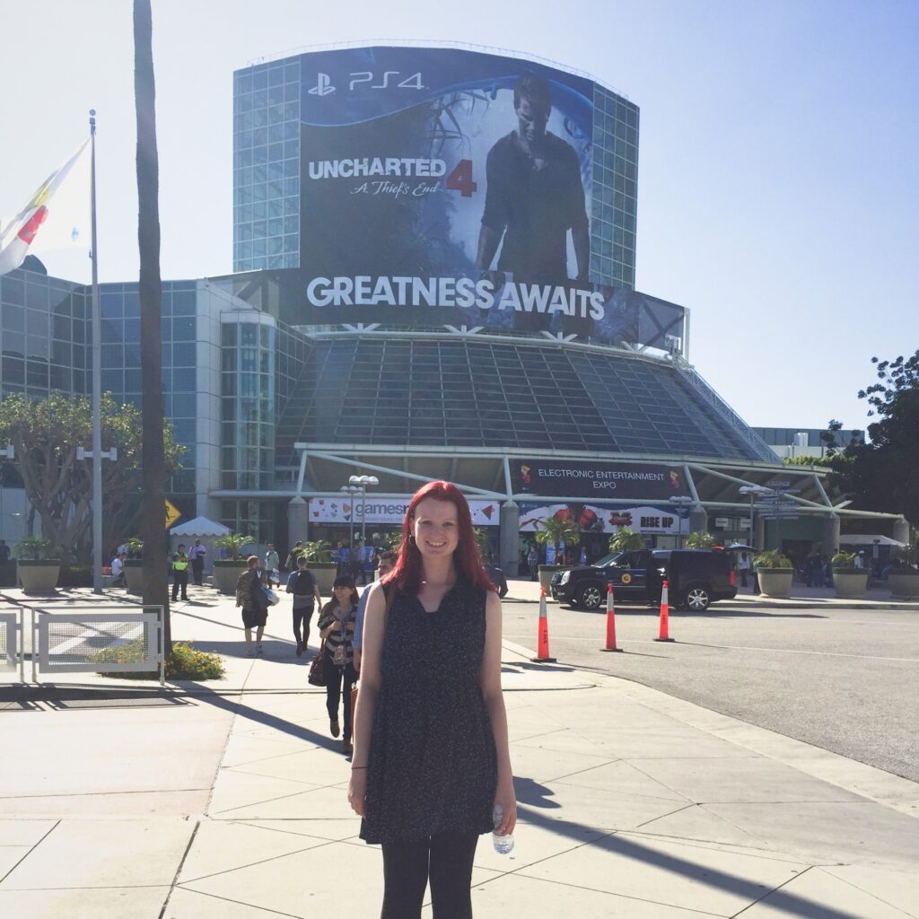 Photo of Ashley standing awkwardly in front of the E3 expo in LA circa 2015